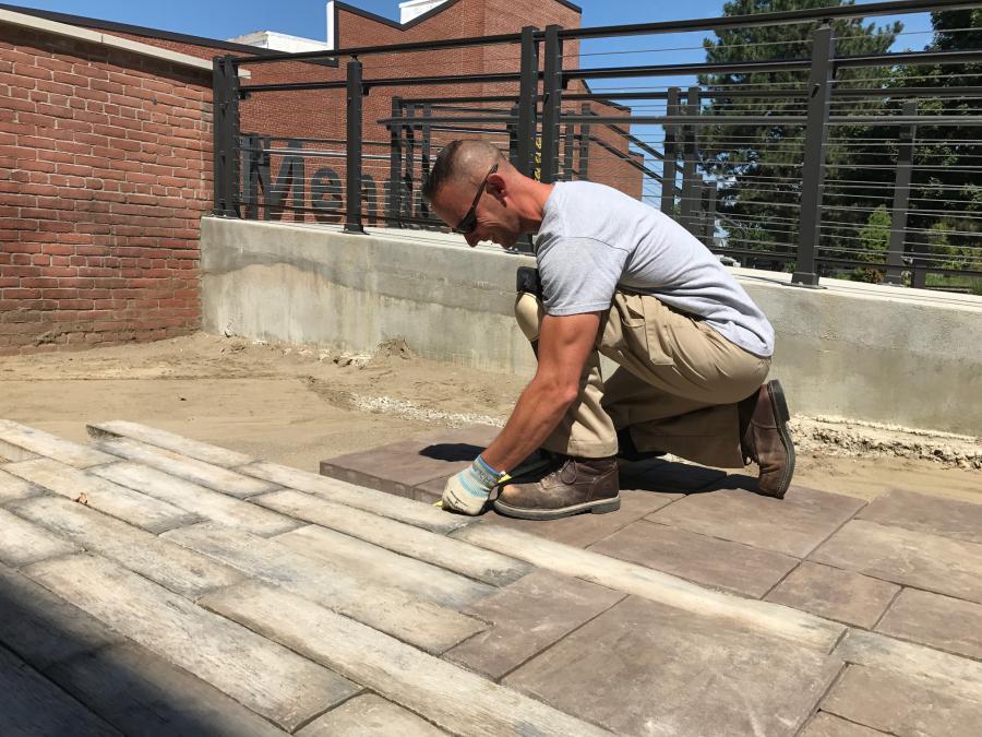 Employee lays pavers at office building