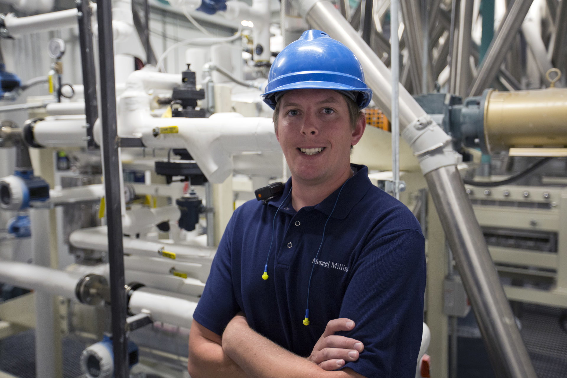 Employee stands against milling equipment